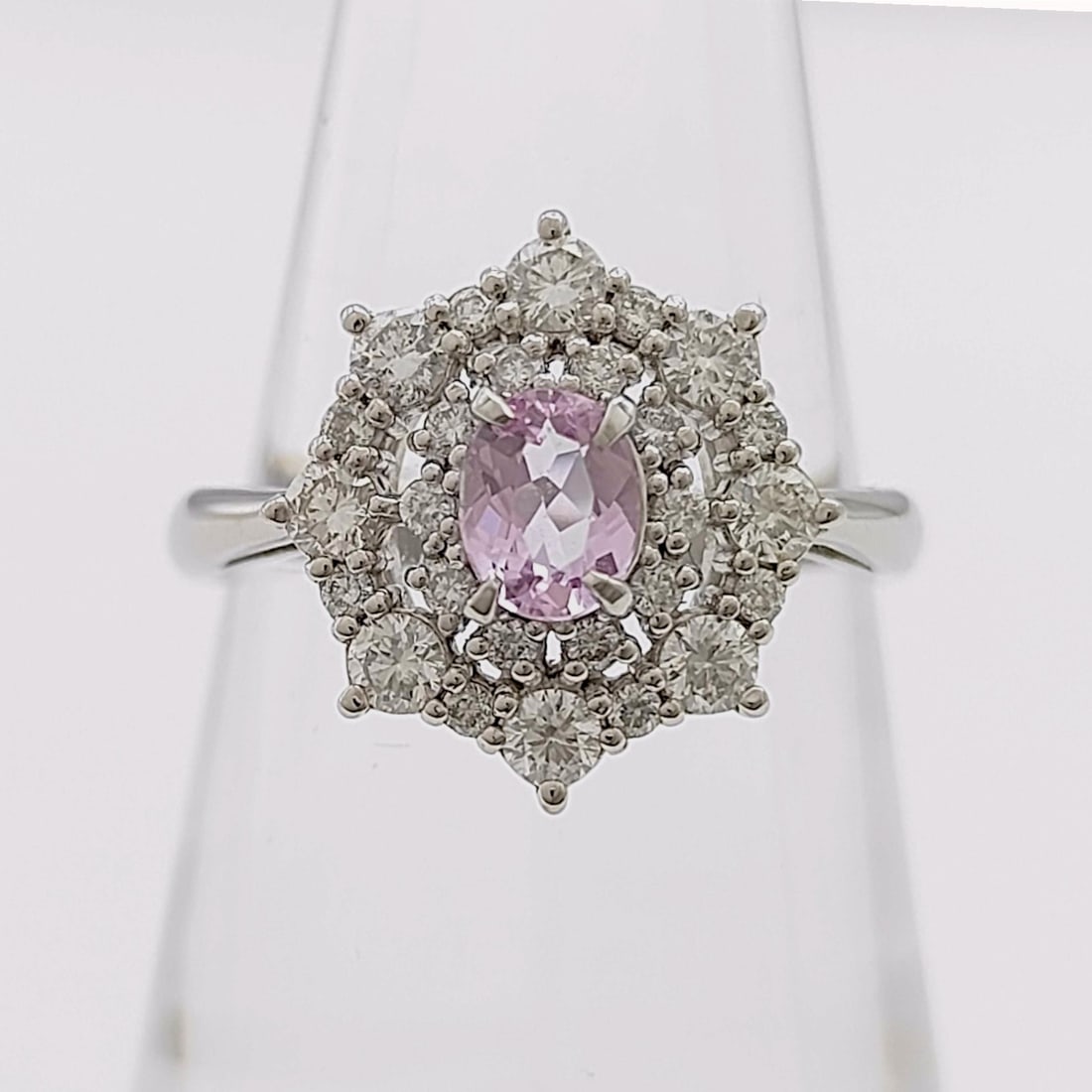 Rare Lavender Imperial Topaz and Diamond Cluster Ring in Platinum: A fine platinum cocktail ring featuring a central oval-cut lavender imperial topaz, weighing approximately 0.39 carats. The center stone is held in a four-prong elevated setting and surrounded by a