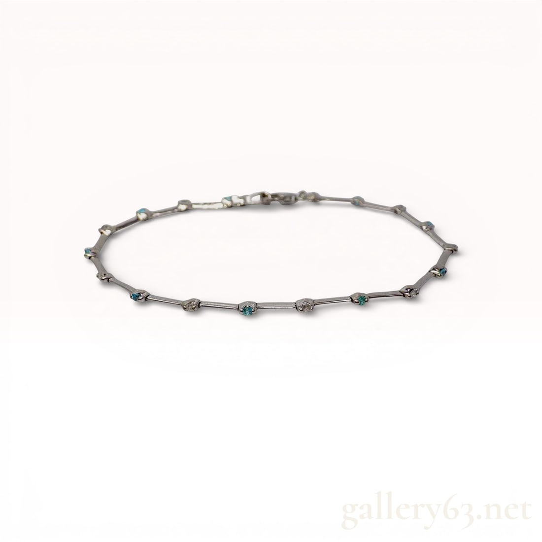 18k White Gold Paraiba Tourmaline and Diamond Bar-Link Bracelet: This fine 18k white gold bracelet features a delicate bar-link design with alternating gemstones bezel-set at each articulated joint. The piece is set with natural round mixed-cut Paraiba tourmalines