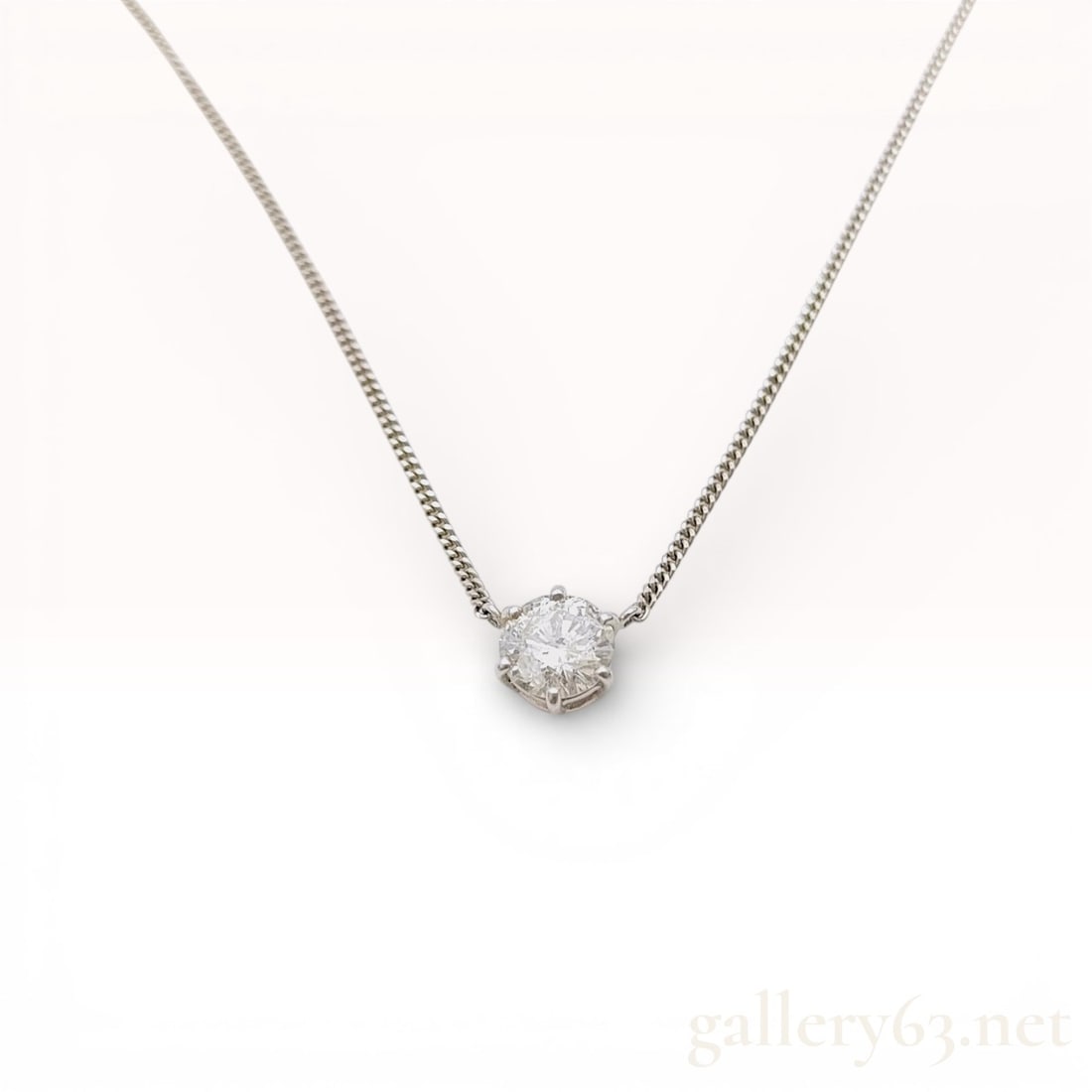 Platinum and 1.28ct Natural Diamond Solitaire Pendant Necklace: A platinum solitaire pendant necklace featuring one round brilliant-cut diamond weighing approximately 1.28 carats. The diamond is secured in a six-prong setting integrated into a platinum curb