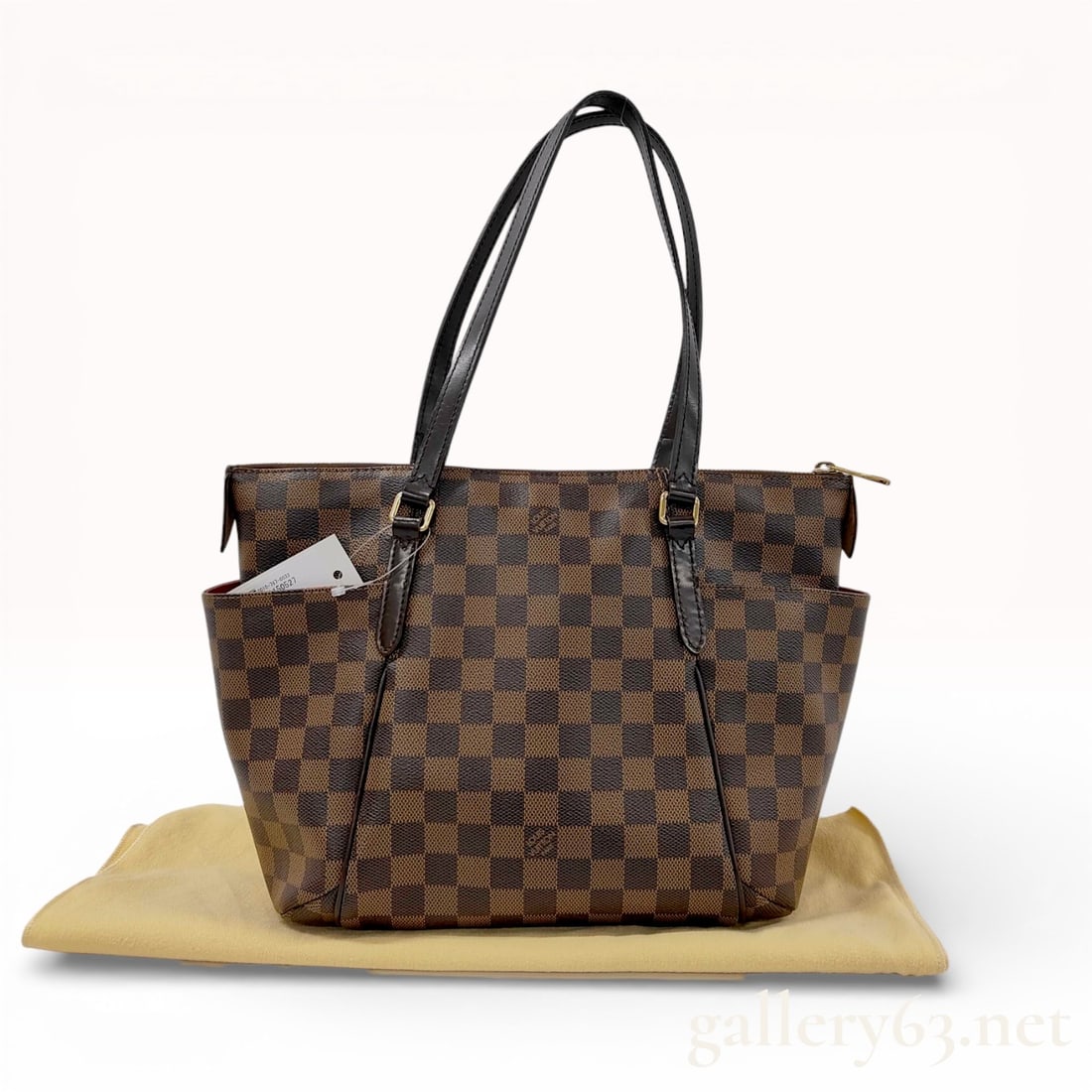 Louis Vuitton Totally MM Damier Ebene Canvas Brown: A Louis Vuitton Totally MM tote bag crafted in signature Damier Ebene checkered coated canvas with dark brown cowhide leather trim. This functional shoulder bag features two exterior side gusset