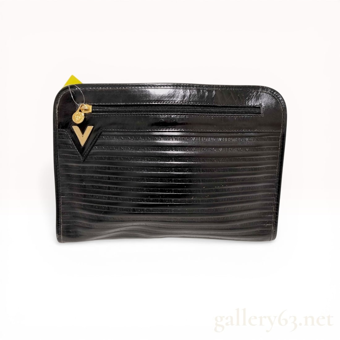 Vintage Mario Valentino Black Embossed Leather Clutch Bag: Mario Valentino vintage clutch bag, late 20th century. Crafted from black semi-gloss leather, the exterior features a repeating embossed logo pattern with horizontal ribbing. The design includes a top