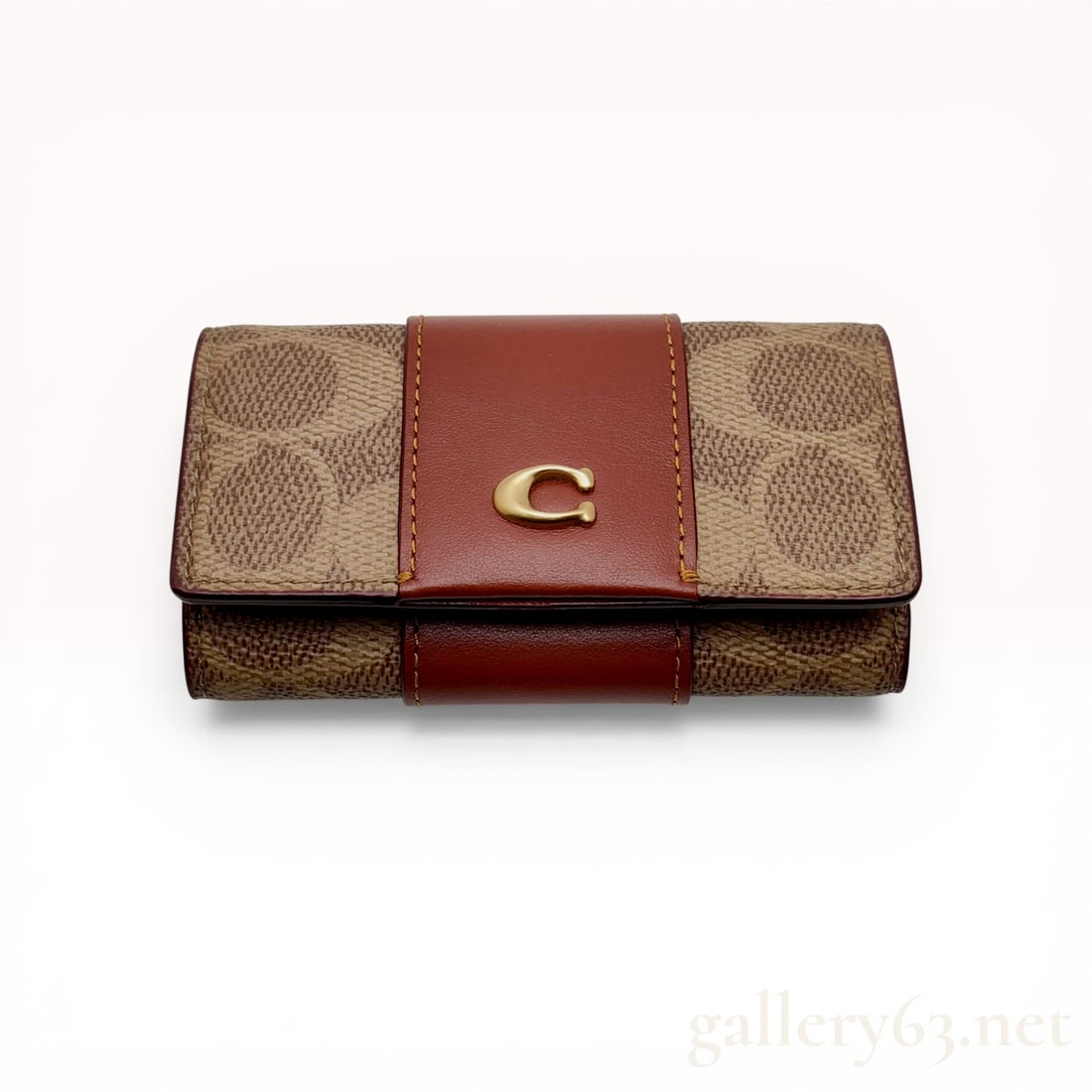 Coach Signature Canvas and Leather 5-Hook Key Case with Detachable Ring: Coach trifold key case in signature coated canvas and refined calf leather. The exterior features tan signature canvas with a central reddish-brown leather band and a gold-tone metal C emblem. The int