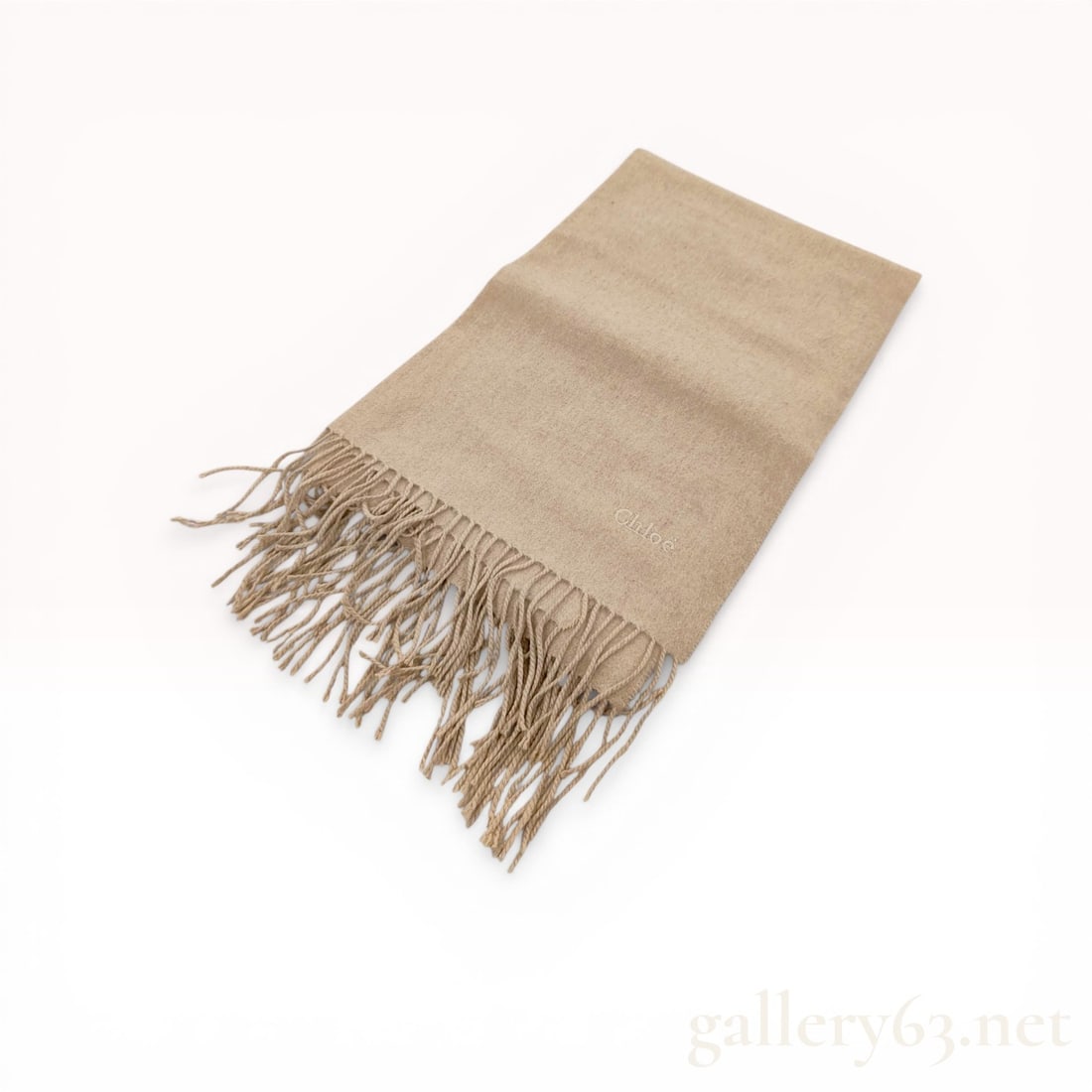Chloe Beige Melange Wool and Cashmere Blend Scarf: Chloe luxury scarf in a neutral beige melange. The textile features a soft, brushed finish composed of a wool or cashmere blend with long, twisted fringe at both ends. A tone-on-tone embroidered Chloe