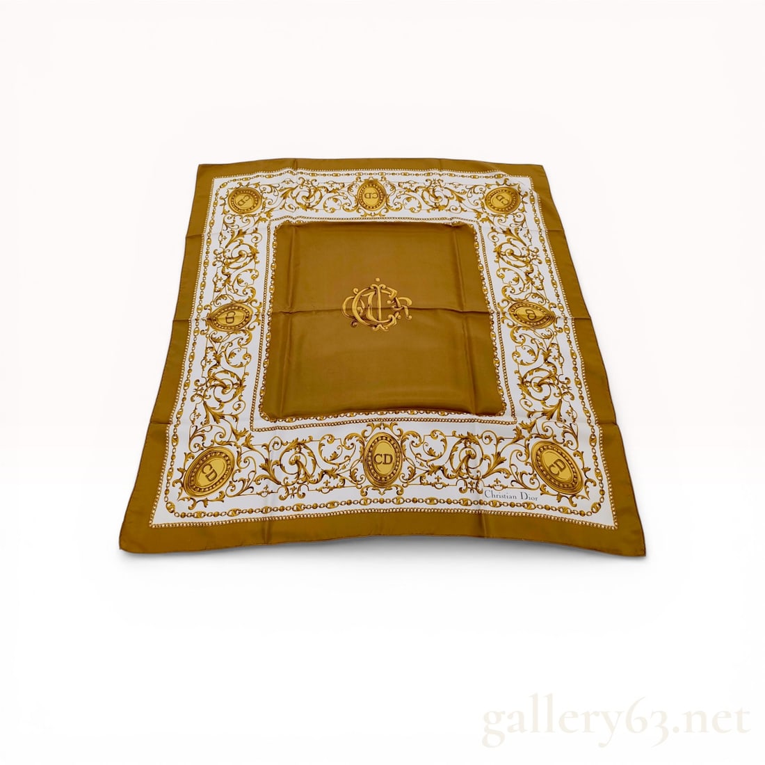 Christian Dior Silk Twill Scarf with Rococo Scrollwork and Monogram Pattern: Christian Dior silk twill square scarf featuring a central ocher-gold panel with a stylized intertwined CD monogram. The design includes a white frame decorated with golden Rococo-style scrollwork,