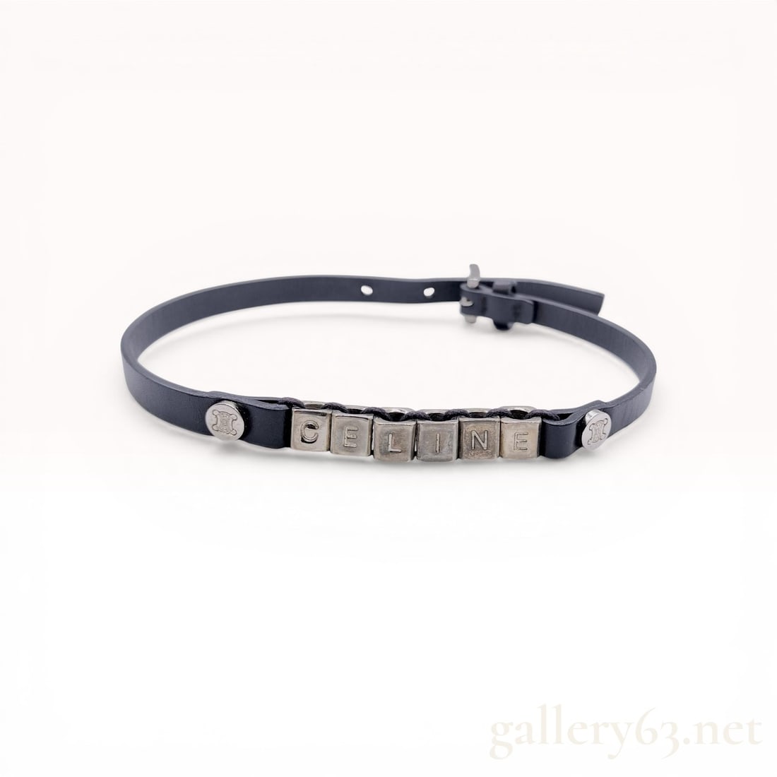 Celine Black Leather and Silver-Tone Cube Logo Bracelet: Celine fashion bracelet featuring a black leather strap adorned with six silver-tone cube beads spelling the brand name. The beads are cord-strung and riveted to the strap with hardware featuring the