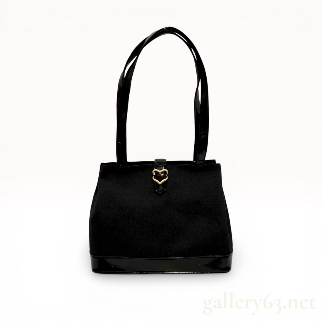 Yves Saint Laurent Vintage Black Fabric and Patent Leather Heart Shoulder Bag: Yves Saint Laurent vintage heart shoulder bag, circa 1990-2010. The bag is composed of a black fabric body with black patent leather trim and features a gold-tone heart-shaped buckle on a magnetic sna