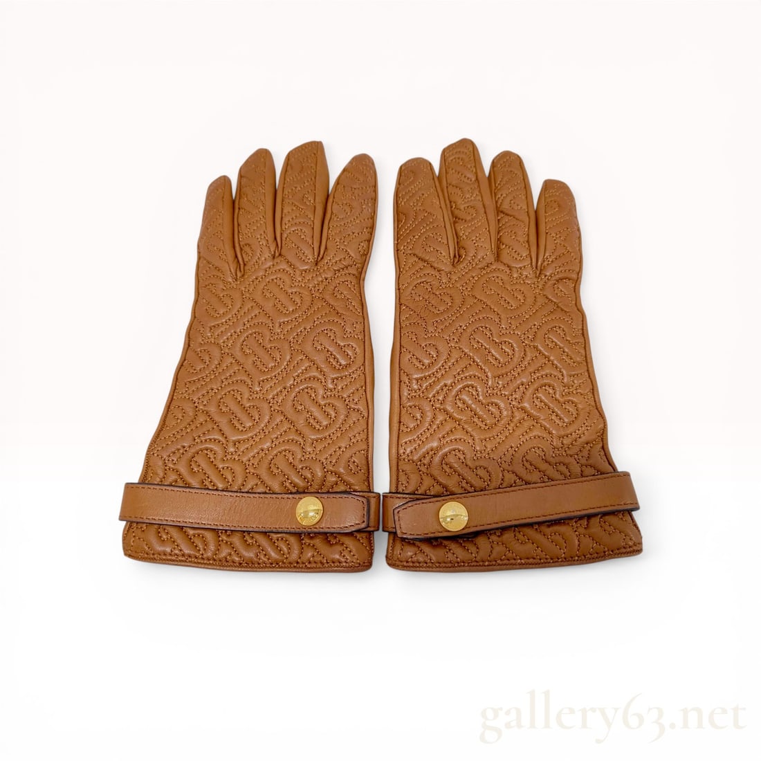 A Pair of Burberry TB Monogram Quilted Leather Gloves: Burberry TB monogram quilted leather gloves, contemporary. The exterior is crafted from supple tan leather featuring an all-over quilted TB monogram pattern on the back and smooth leather palms. Each