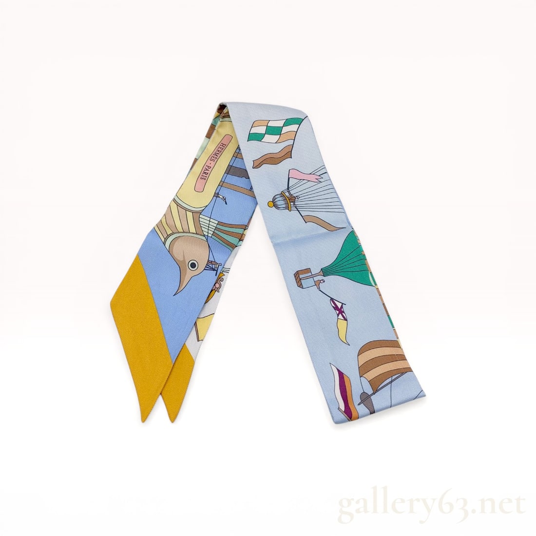 Herm?¨s Les Folies du Ciel Silk Twilly Scarf: Hermès silk twilly scarf in the Les Folies du Ciel pattern, featuring an aeronautical theme with vintage hot air balloons, parachutes, and doves. The design is printed on 100% silk twill with a