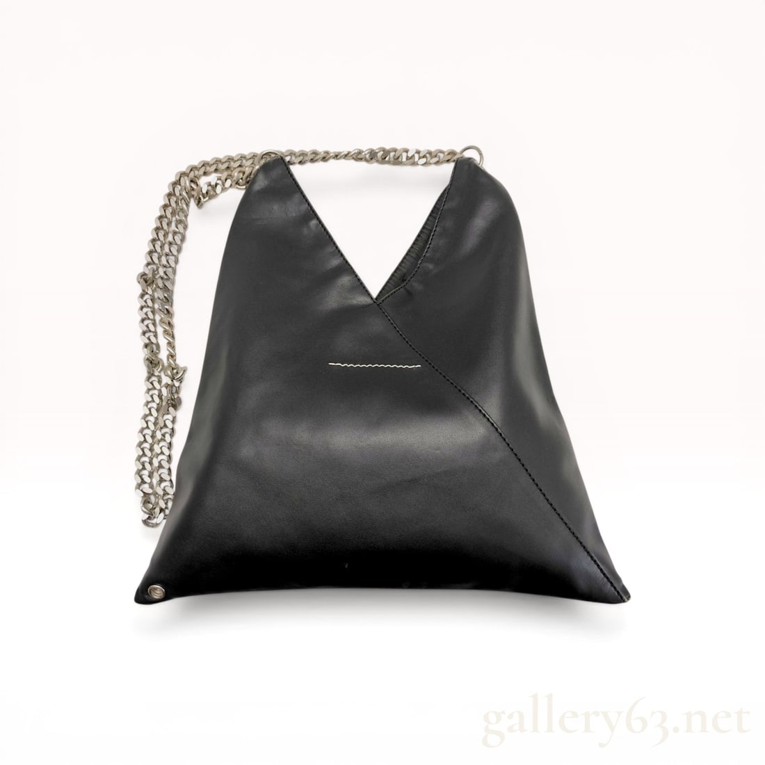 MM6 Maison Margiela Japanese Triangle Chain Bag: MM6 Maison Margiela Japanese triangle shoulder bag in black leather. This origami-inspired silhouette features a silver-tone curb-link chain strap, signature horizontal white stitch, and snap-button c