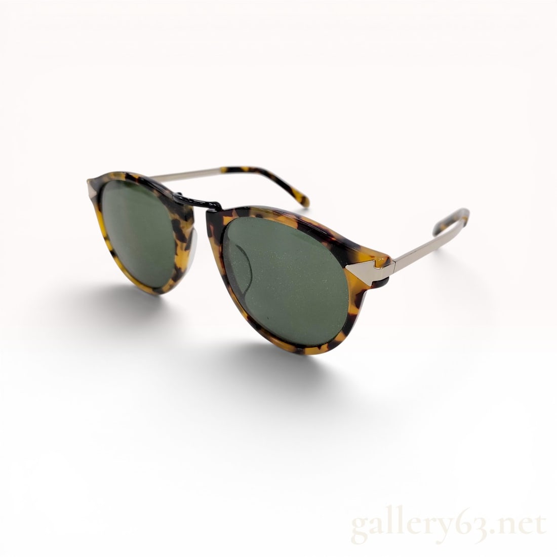 Karen Walker Helter Skelter Tortoiseshell Sunglasses with Case: Karen Walker Helter Skelter sunglasses featuring round tortoiseshell acetate frames and dark green tinted lenses. The design incorporates a black metal bridge and silver-tone metal temples accented wi