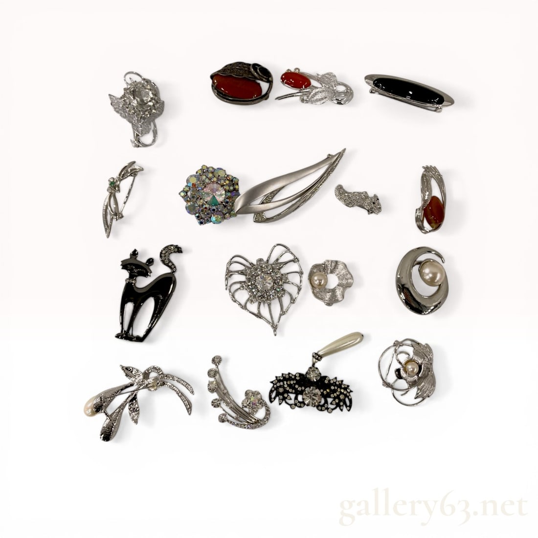 A Collection of 15 Vintage Costume Jewelry Brooches and Pins: This assortment of 15 vintage costume jewelry brooches features a variety of mid-century modern, animal, and floral designs. The pieces are constructed from silver-toned and gunmetal-toned base metals