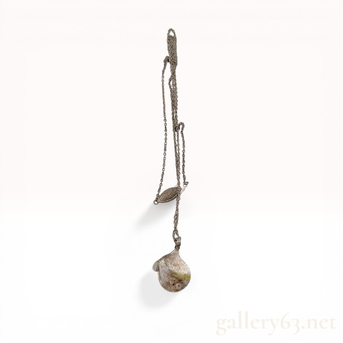 Mikimoto Sterling Silver and Cultured Pearl Oyster Shell Pendant Necklace: Mikimoto sterling silver and cultured pearl pendant necklace. The cast silver pendant is designed as an open oyster shell set with a single round white cultured pearl and suspended from a fine cable l