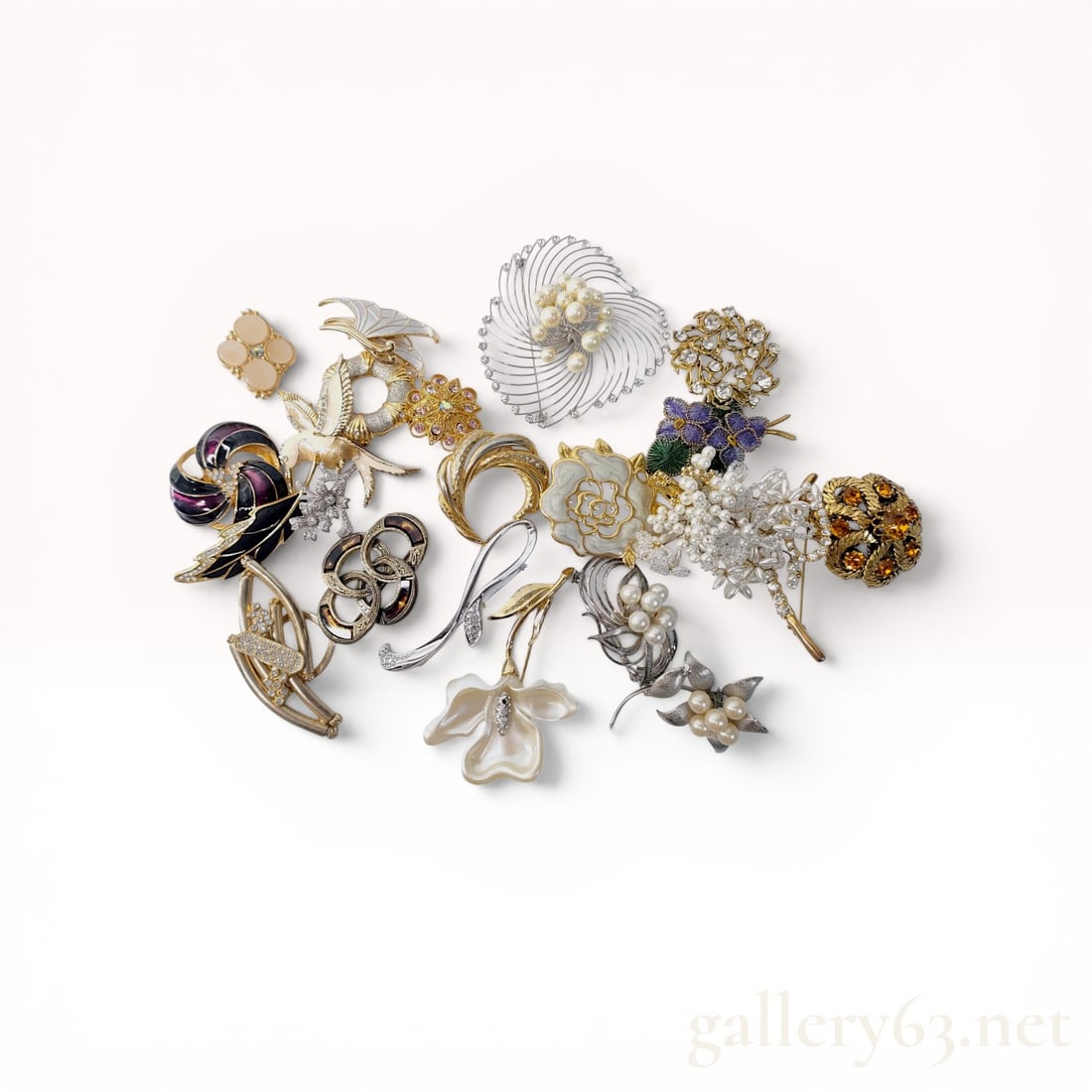 An Assortment of Vintage and Contemporary Costume Jewelry Brooches and Pins: A collection of vintage and contemporary costume jewelry brooches and pins, including a Celtic-style intertwined knot brooch marked Miracle. The group features diverse motifs such as an enameled hummi