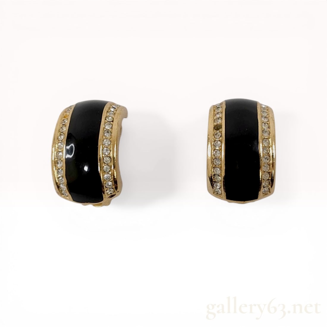 A Pair of Christian Dior Vintage Black Enamel and Rhinestone C-Hoop Earrings: A pair of Christian Dior vintage wide C-hoop clip-on earrings, late 20th century. Gold-toned metal construction featuring a central black enamel band flanked by rows of clear round-cut rhinestones. Ea