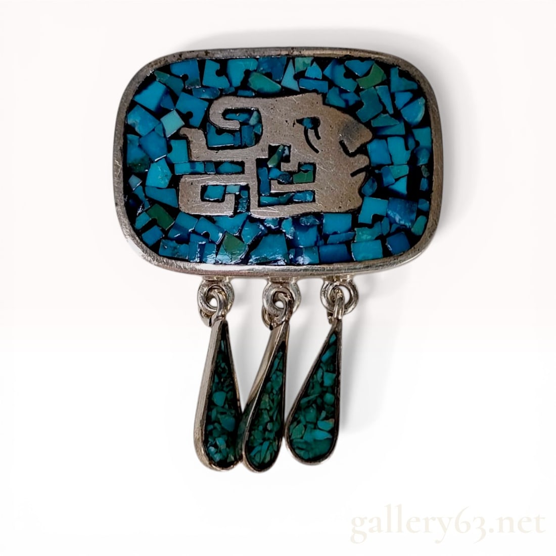 Mexican Taxco Sterling Silver and Turquoise Inlay Elephant Pendant-Brooch: Mexican Taxco sterling silver pendant-brooch, late 20th century. The rectangular frame features a raised stylized elephant motif set against a crushed turquoise chip inlay ground and is embellished wi