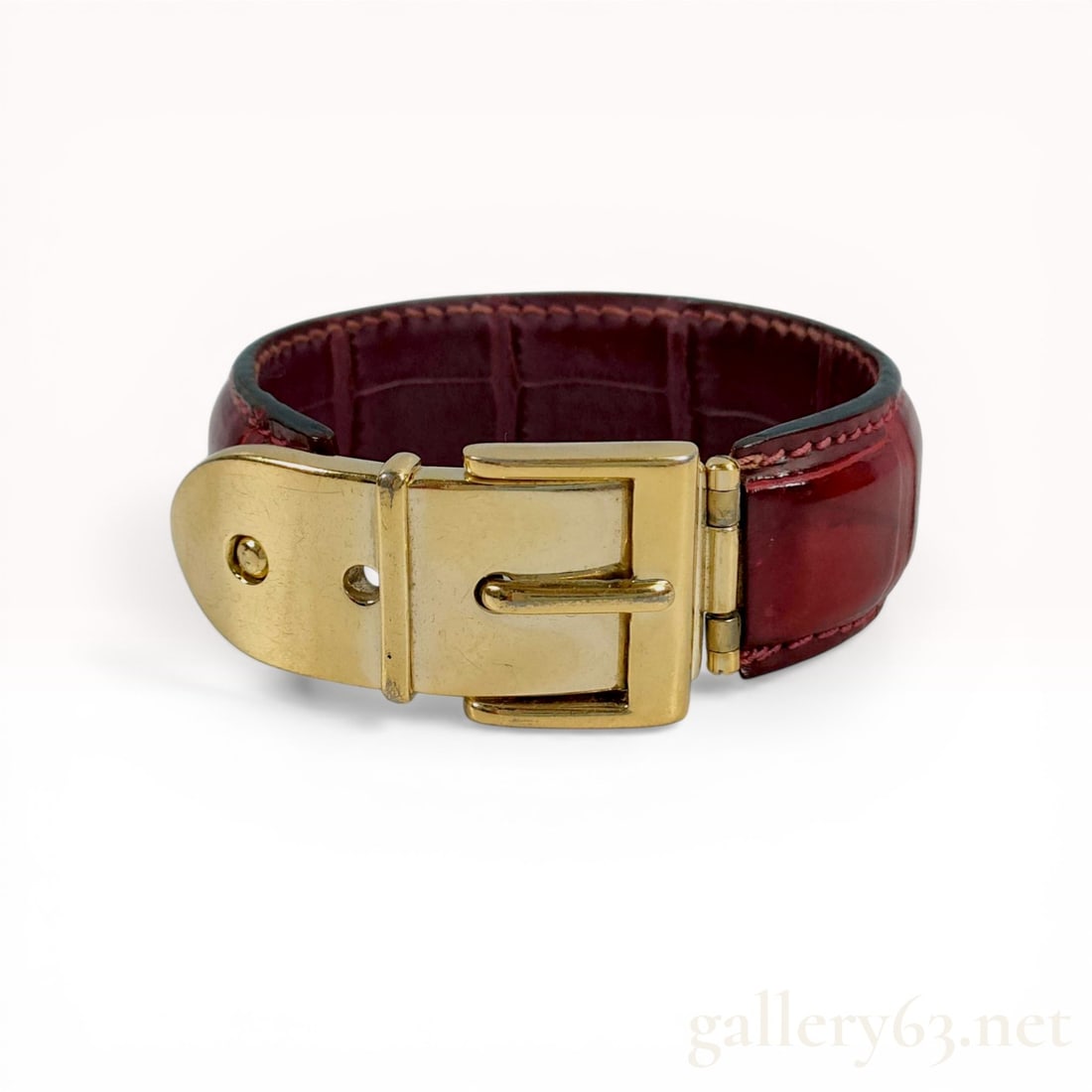 Gucci Burgundy Crocodile Belt Style Buckle Bracelet: Gucci belt-style cuff bracelet featuring a burgundy exotic skin band. The band is crafted from crocodile or alligator leather with a large rectangular scale pattern and black glazed edges. The closure