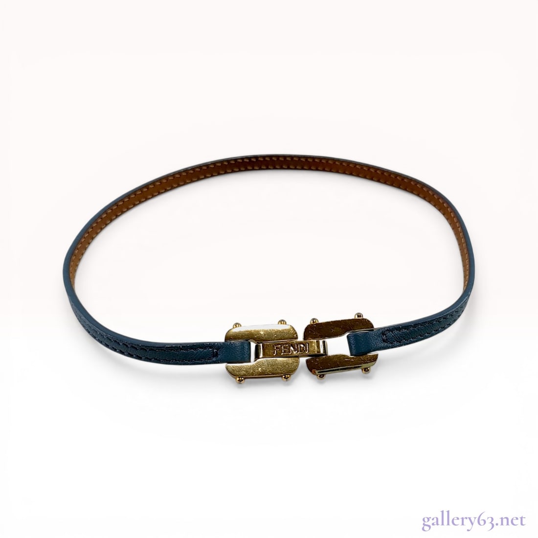 Fendi Blue Leather and Gold-Tone Clasp Bracelet: Fendi leather clasp bracelet, contemporary. The piece features a slender blue leather strap with a contrasting brown leather lining and tonal stitching, finished with a mechanical gold-tone link-style