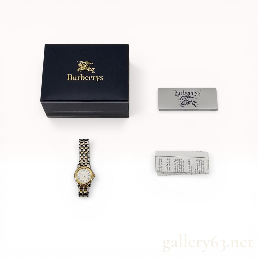 Burberrys Two-Tone Ladies Quartz Dress Watch 6031-G13435 Y: Burberrys ladies dress watch, model 6031-G13435 Y, featuring a Japanese quartz movement. The timepiece is constructed with a two-tone base metal case and an integrated link bracelet with a signed fold