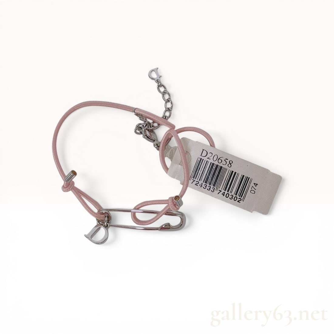 Dior Pink Textile Cord and Silver-Tone Safety Pin Bracelet: Christian Dior fashion bracelet featuring a pink woven textile cord and silver-tone metal hardware. The central design element is a large safety pin charm with a suspended D initial charm engraved wit