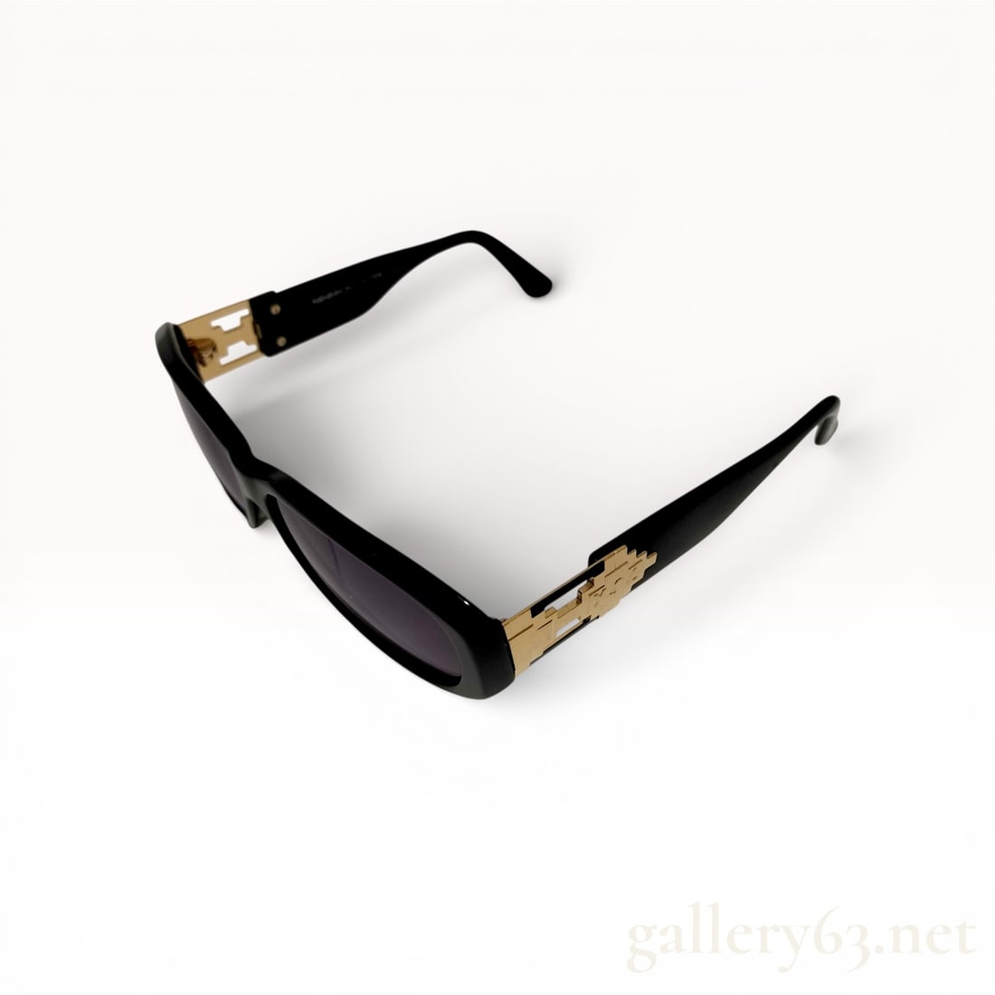Yves Saint Laurent Black Acetate Sunglasses Model 31-7506: Yves Saint Laurent designer sunglasses, model 31-7506, late 20th century. The rectangular wrap-around frames are crafted from polished black acetate with dark-tinted lenses and decorative gold-tone me