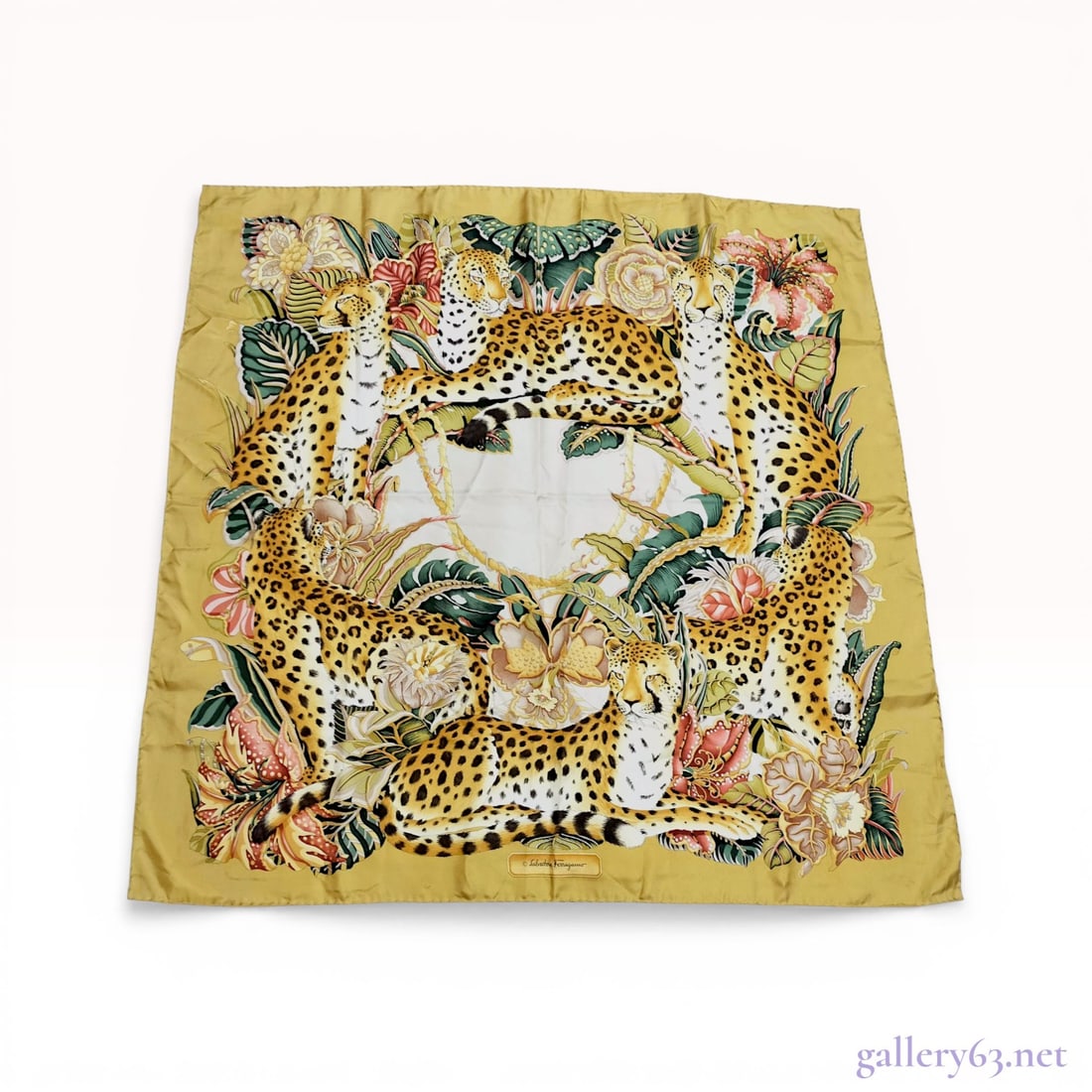 Salvatore Ferragamo Cheetahs Print Silk Jungle Scarf: Salvatore Ferragamo silk twill scarf featuring a jungle animal motif. The design depicts five cheetahs amidst tropical foliage including monstera leaves and hibiscus flowers surrounding a central off-