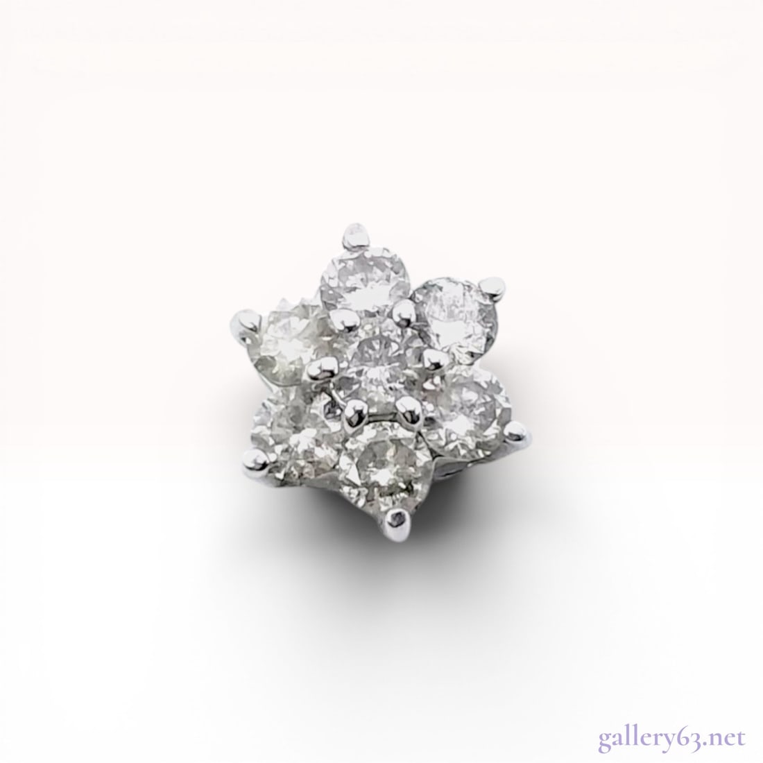 Single Diamond and 14 Karat White Gold Flower Cluster Slide Pendant: 14 karat white gold slide pendant in a floral cluster design featuring seven prong-set round brilliant-cut diamonds. The piece is constructed with an open framework for use as a slider on a chain rath