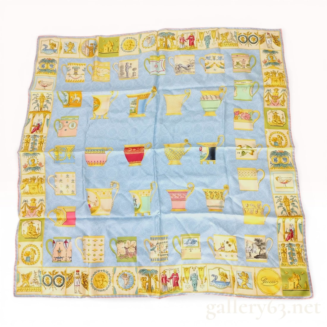 Gucci Silk Scarf with Neoclassical Cup and Vessel Pattern: Gucci square silk scarf featuring a neoclassical cup and vessel motif, circa 1990s. The design consists of a light blue damask-patterned center field with various decorative vessels, surrounded by a b
