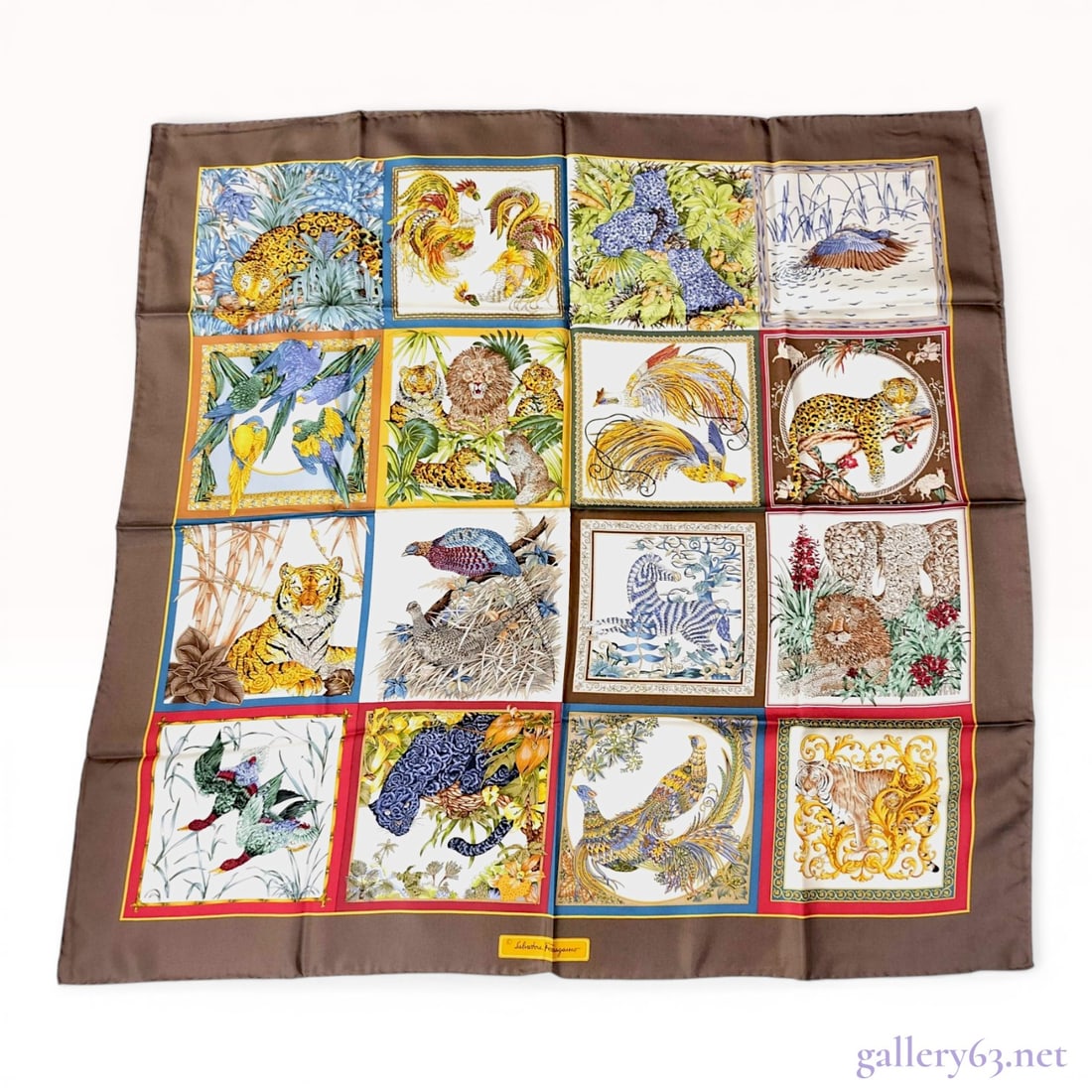 Salvatore Ferragamo Silk Animalier Safari Theme Scarf: Salvatore Ferragamo silk scarf featuring a sixteen-panel grid design of various wildlife and botanical vignettes. The illustrative pattern includes leopards, tigers, lions, zebras, and various birds s