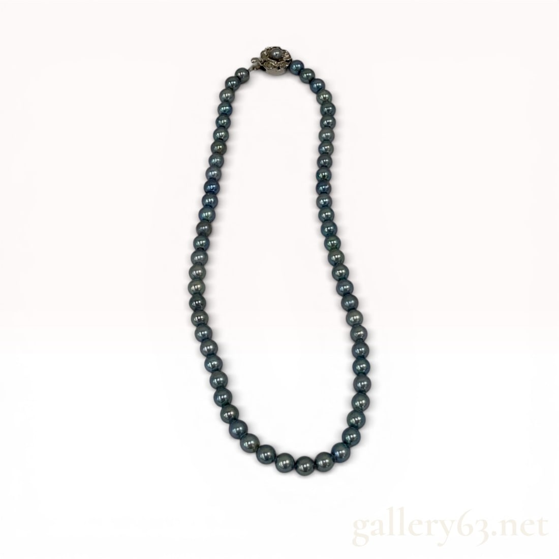 Japanese Akoya Cultured Black Pearl Strand Necklace with Silver Clasp: Single-strand necklace featuring cultured Akoya pearls with a dark grey-to-black body color and peacock iridescent overtones. The hand-knotted strand is secured by a silver filigree floral-form box cl