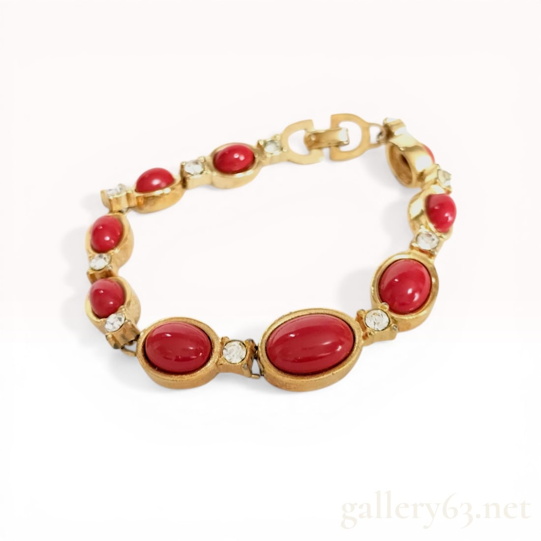 Christian Dior Gold-Tone Link Bracelet with Red Cabochons and Crystals: Christian Dior costume jewelry link bracelet, manufactured in Germany by Henkel and Grosse, late 20th century. The design features alternating oval red cabochons in bezel settings and circular links s