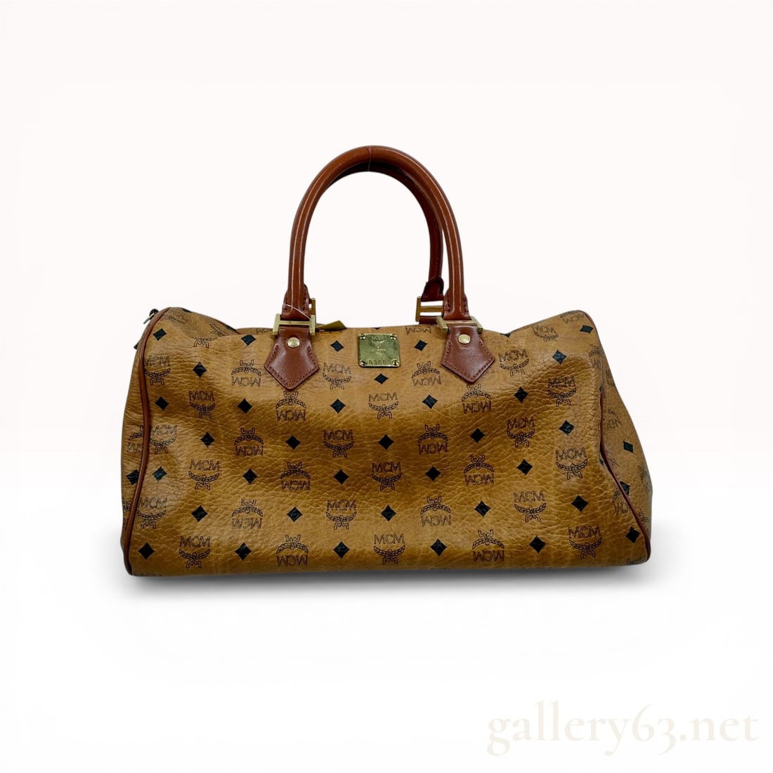 MCM Vintage Visetos Cognac Boston Bag: MCM vintage Boston bag in signature cognac Visetos coated canvas with brown leather trim. The exterior features the classic monogram print, dual rolled leather handles, and gold-tone hardware includin