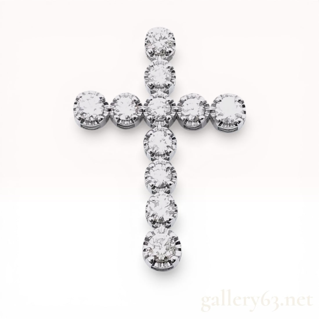 Platinum 950 and Diamond Cross Pendant: A platinum and diamond cross pendant featuring eleven round brilliant-cut diamonds. The diamonds are individually secured in four-prong basket settings joined to form a Latin cross with an integrated