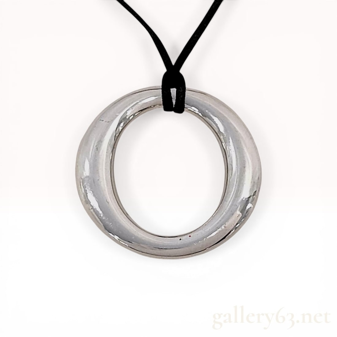 Tiffany & Co. Elsa Peretti Sevillana Sterling Silver Pendant Necklace: Tiffany & Co. Elsa Peretti Sevillana pendant necklace. The circular sterling silver ring pendant is suspended from a black cord by a loop knot. The reverse of the pendant is marked Tiffany & C