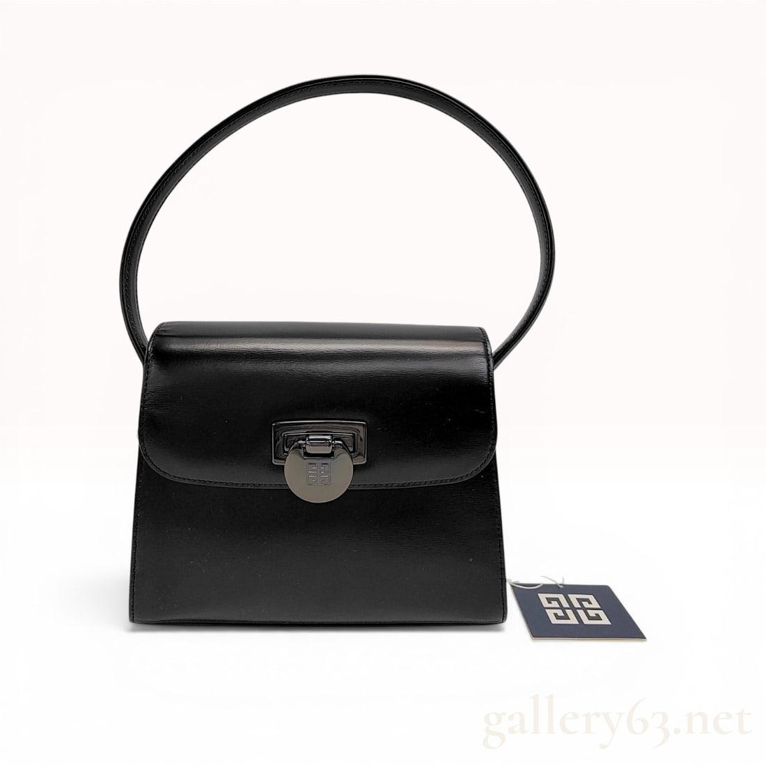 Givenchy Vintage Black Leather 4G Top Handle Flap Bag: Givenchy vintage top handle flap bag featuring a structured trapezoidal body in smooth black leather. The design includes a high-arching top handle, a rear exterior slip pocket, and a front flap with