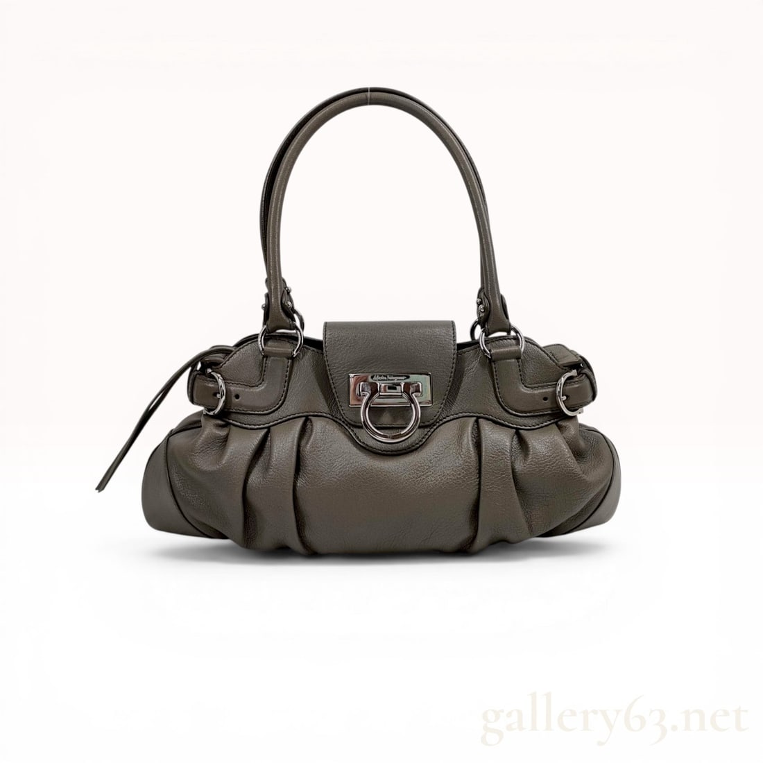 Salvatore Ferragamo Gancini Marisa Grained Leather Handbag: Salvatore Ferragamo Marisa handbag in taupe grained leather. The design features a pleated body with double rolled leather handles, decorative side buckles, and a front flap secured by a signature sil