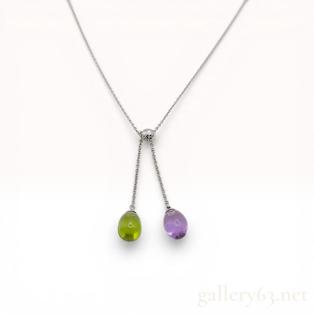 Tiffany & Co. 18K White Gold Rainbow Drops Peridot and Amethyst Lariat Necklace: Tiffany & Co. Rainbow Drops lariat necklace in 18 karat white gold. The design features a fine cable link chain with an adjustable sliding spherical bead leading to two asymmetric drops set with t
