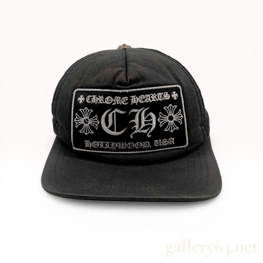 Chrome Hearts CH Hollywood Trucker Hat Black: Chrome Hearts trucker-style baseball cap in black featuring a large embroidered front patch with the brand name and Hollywood, USA text. The hat is constructed with a cotton front and brim, a polyeste