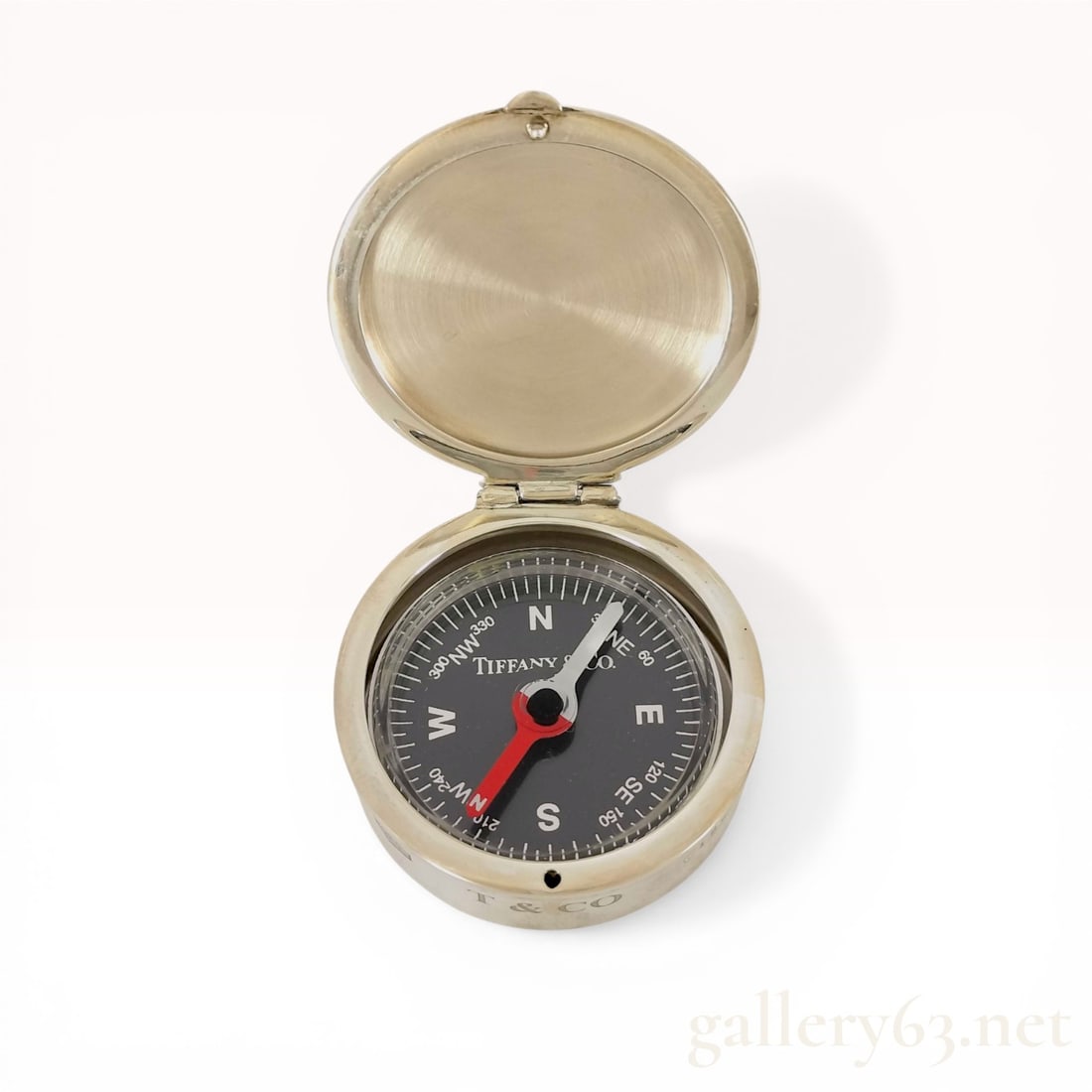 Tiffany and Co. 1837 Collection Sterling Silver Pocket Compass: Tiffany and Co. sterling silver pocket compass from the 1837 collection, contemporary. The instrument features a circular case with a hinged lid and a black dial displaying cardinal directions and num