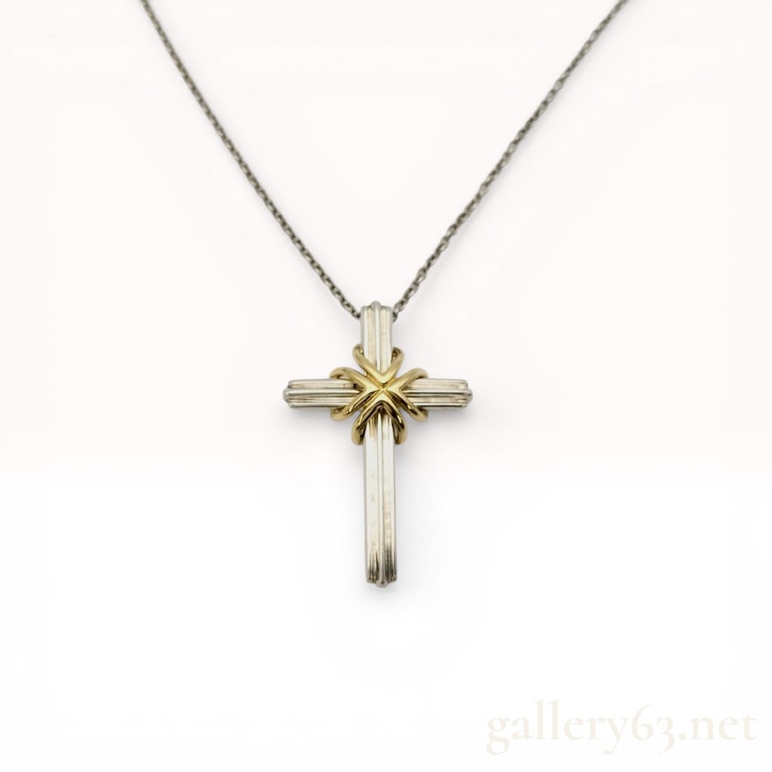 Tiffany & Co. Sterling Silver and 18K Yellow Gold Signature Cross Pendant Necklace: Tiffany & Co. Signature Cross pendant necklace crafted in sterling silver and 18 karat yellow gold. The design features a ribbed sterling silver cross with a central 18 karat yellow gold X-motif,