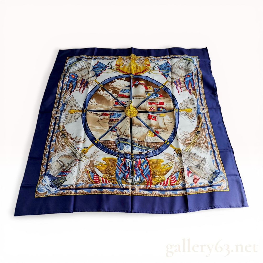 Herm?¨s Vive le Vent 90cm Silk Twill Scarf: Hermès silk twill scarf in the Vive le Vent pattern, late 20th century. The maritime design features a central sailing vessel framed by a ship's wheel and international flags, set against a whi
