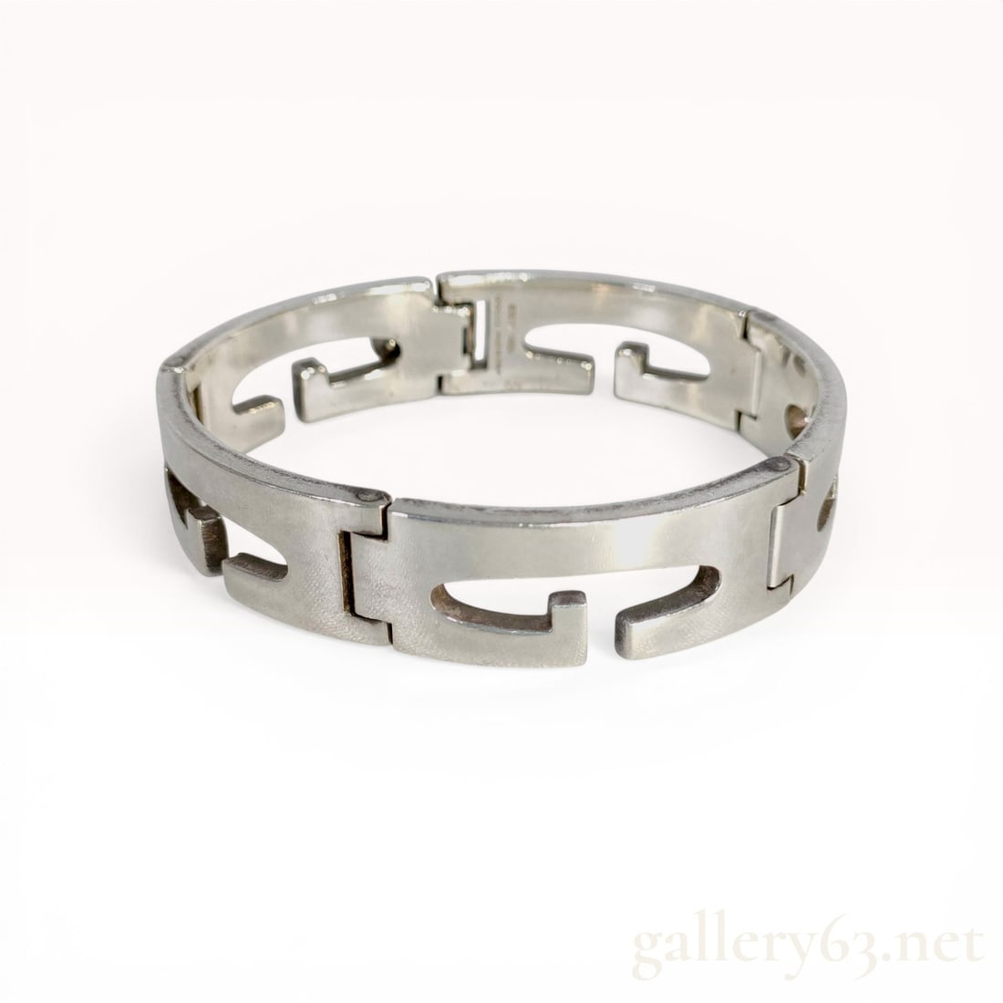 Gucci Sterling Silver G Motif Link Bracelet: Gucci sterling silver link bracelet featuring repeating cutout G logo motifs. The piece is constructed with hinged links and an integrated fold-over box clasp with a tongue-and-bar mechanism. Hallmark