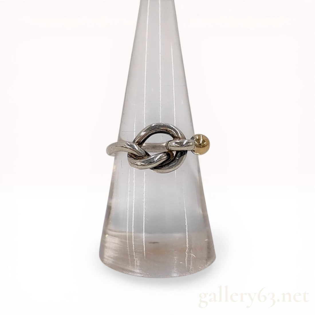 Tiffany and Co. Sterling Silver and 18 Karat Yellow Gold Hook and Eye Ring: Tiffany and Co. sterling silver and 18 karat yellow gold ring in the Hook and Eye pattern. The design features a slender sterling silver band forming a knot-style closure accented by a single 18 karat