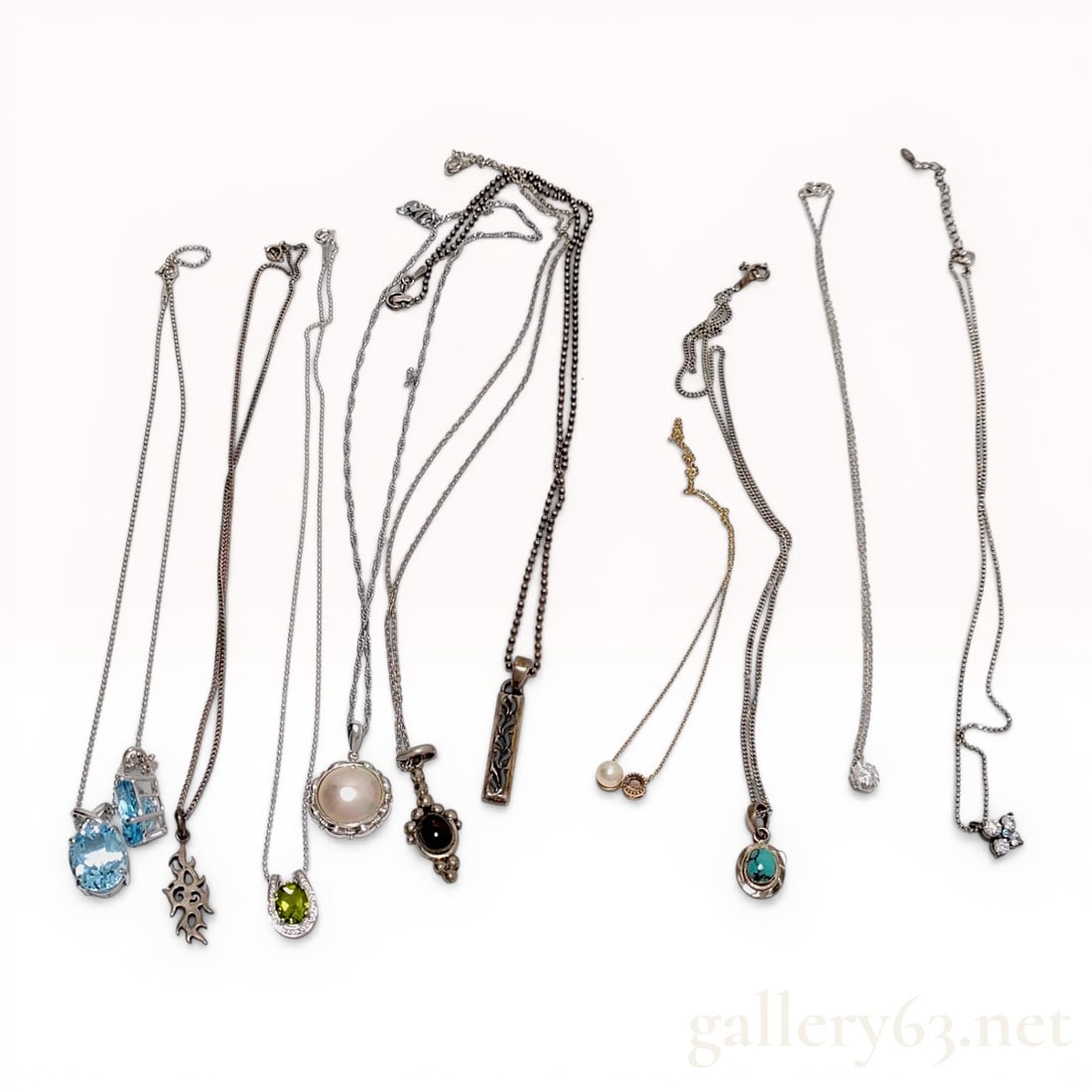 A Set of 10 Sterling Silver and Mixed Gemstone Pendant Necklaces: This collection consists of ten necklaces featuring various pendants primarily crafted from sterling silver with a variety of gemstone accents. The assortment includes faceted light blue stones, a gre