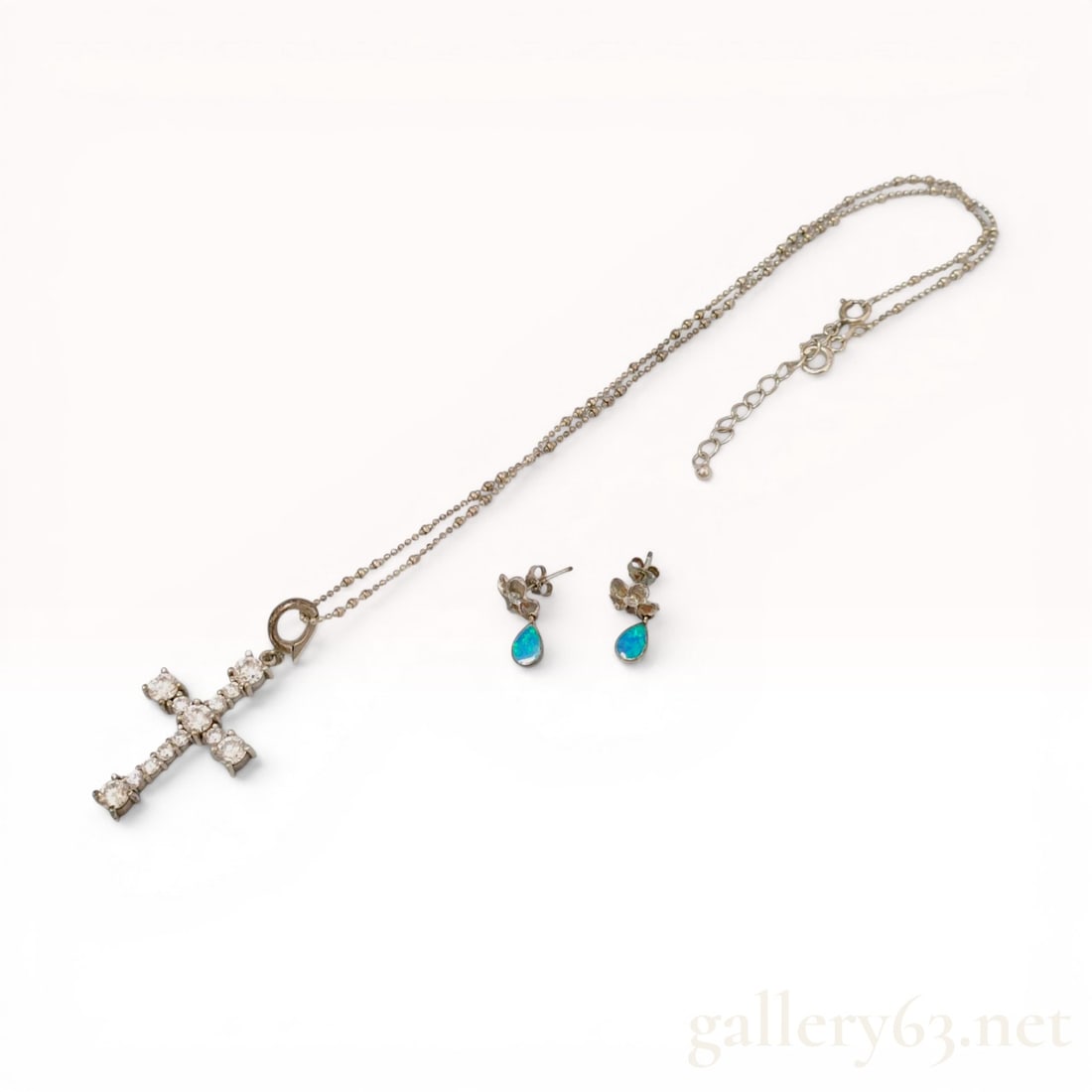 Sterling Silver Cross Pendant Necklace and Opal Floral Drop Earring Set: Sterling silver jewelry set featuring a cross pendant necklace and opal floral drop earrings. The cross is prong-set with twelve round-cut clear stones and features a hinged bail on a silver bead chai