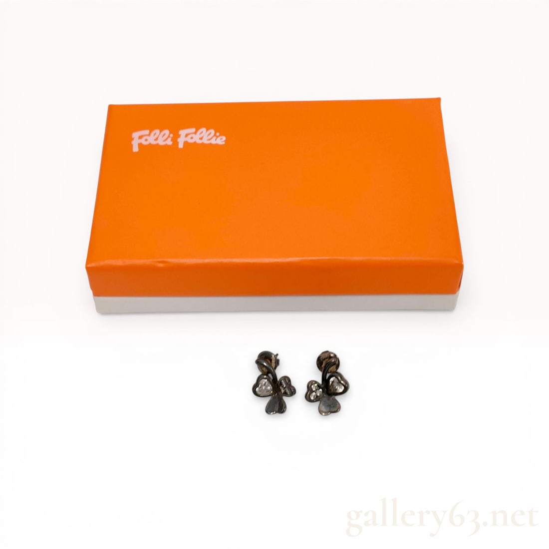 A Pair of Folli Follie Sterling Silver Heart Clover Stud Earrings: A matched pair of Folli Follie sterling silver stud earrings featuring a three-leaf clover motif with heart-shaped petals. One petal is set with a heart-shaped clear faceted stone, another with three