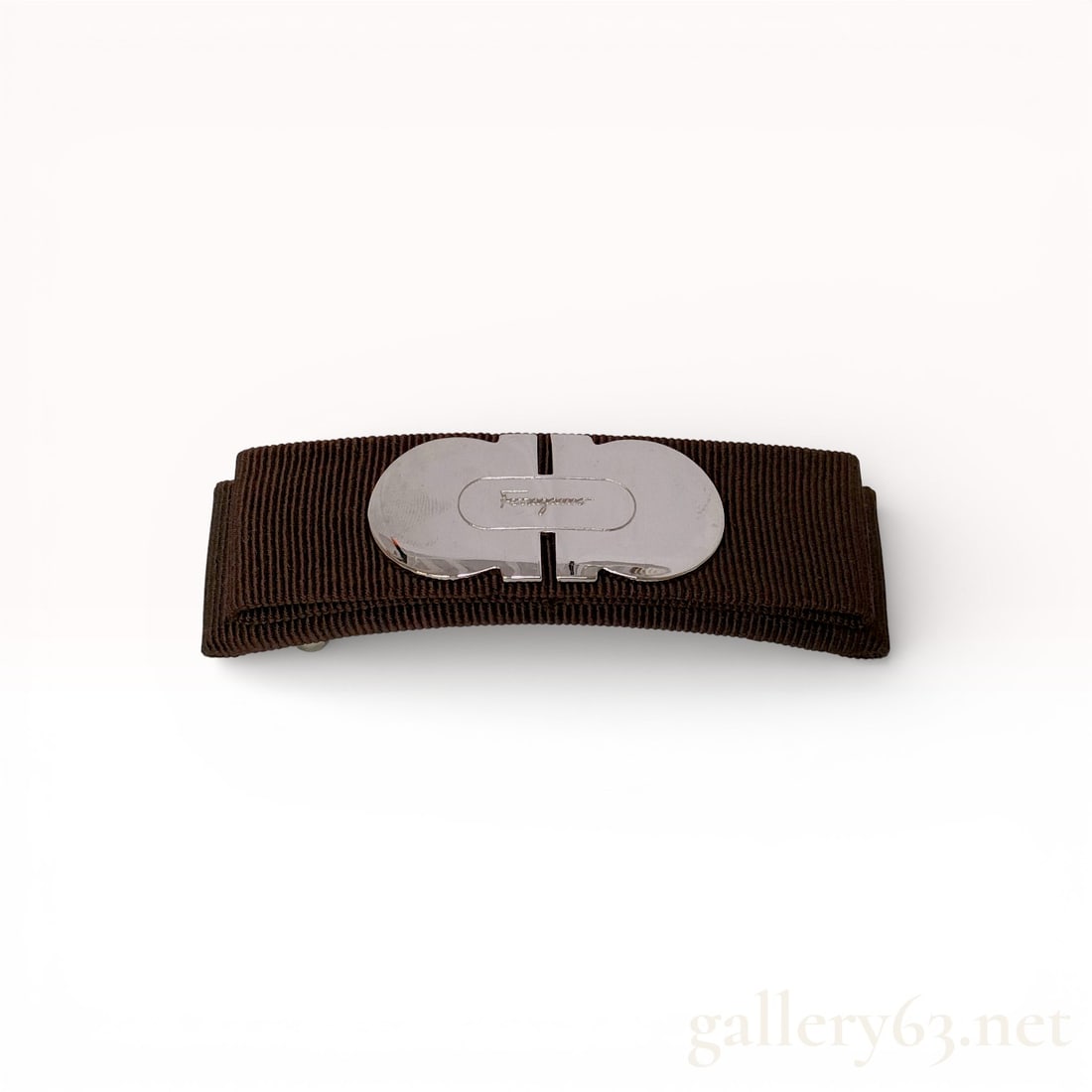 Salvatore Ferragamo Gancini Grosgrain Ribbon Hair Barrette: Salvatore Ferragamo hair barrette featuring a dark brown grosgrain ribbon bow and a silver-tone metal Gancini plate. The center hardware is engraved with the Ferragamo script logo and the reverse is f