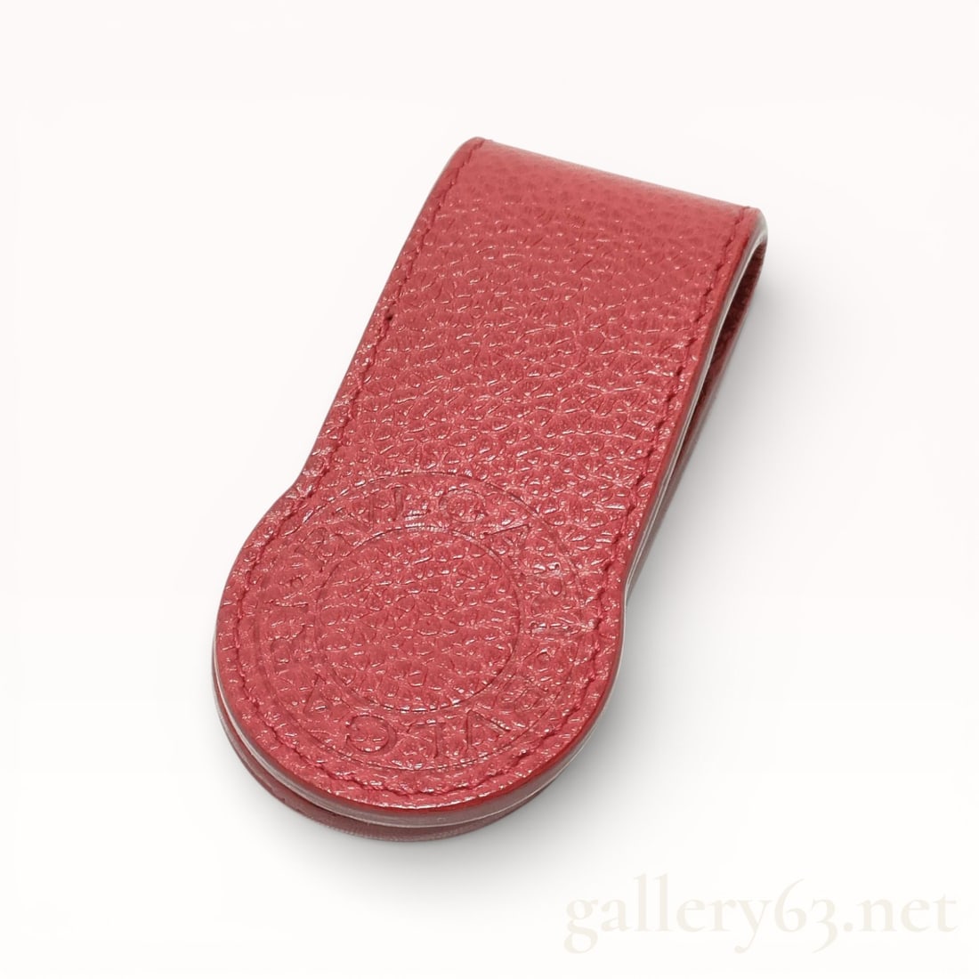 Bvlgari Red Pebbled Leather Magnetic Money Clip: Bvlgari magnetic money clip in red pebbled leather. The accessory features a fold-over design with internal magnets and a large circular embossed BVLGARI BVLGARI logo on the rounded terminal. It is fi