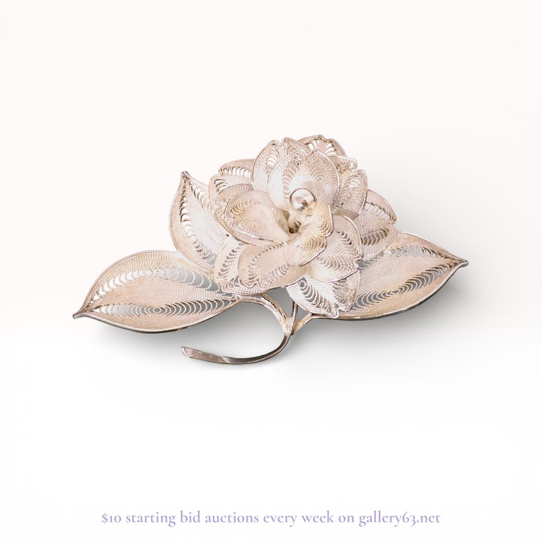 Japanese Pure Silver Filigree Floral Brooch: Mid-20th century Japanese floral brooch crafted in pure silver. The naturalistic design features a central multi-layered blossom with a polished bead stamen, flanked by three leaves on a curved stem.