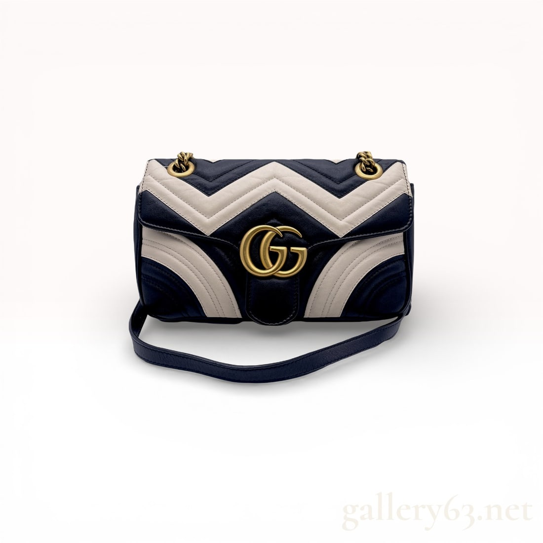 Gucci GG Marmont Small Matelasse Bi-Color Leather Shoulder Bag: Gucci GG Marmont small shoulder bag in bi-color black and off-white chevron matelasse leather. The exterior features an antique gold-tone interlocking GG logo on the front flap and a quilted heart mot