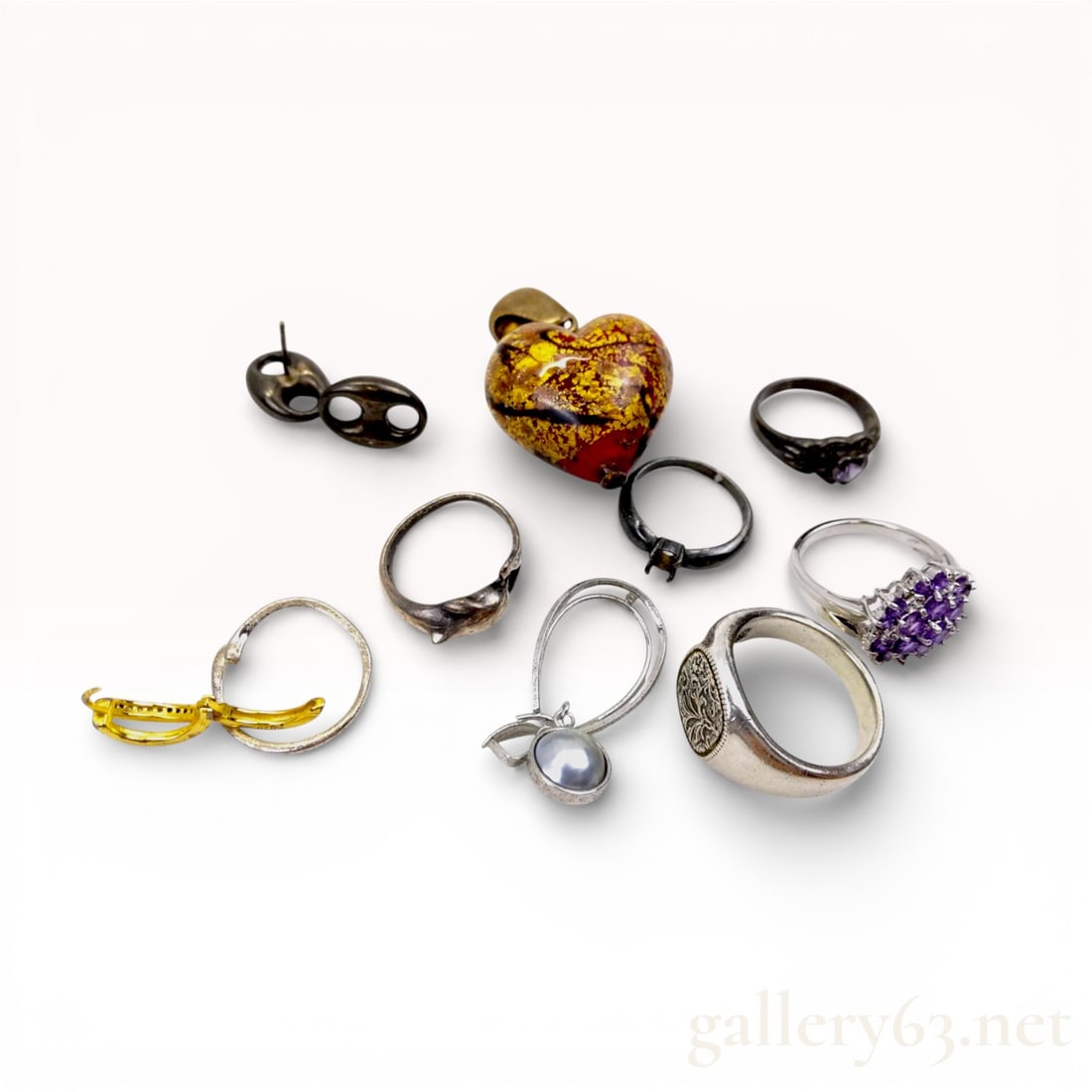 A Collection of Sterling Silver and Assorted Costume Jewelry: A collection of sterling silver and assorted costume jewelry, late 20th century. Features include an amethyst-colored cluster ring, a floral signet band, and a red aventurine-style glass heart pendant